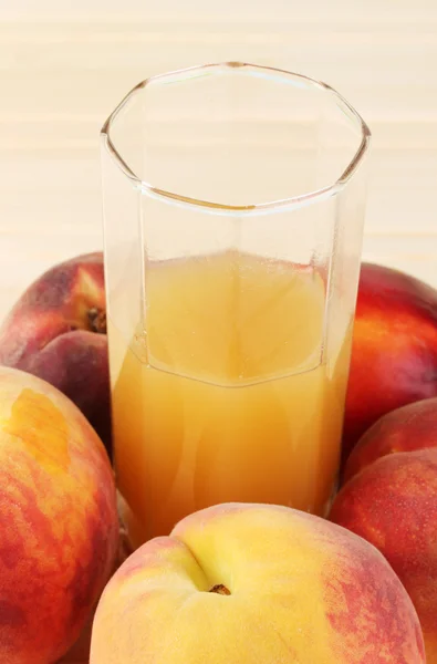 Ripe peaches and juice close-up on wooden table — Stock Photo, Image