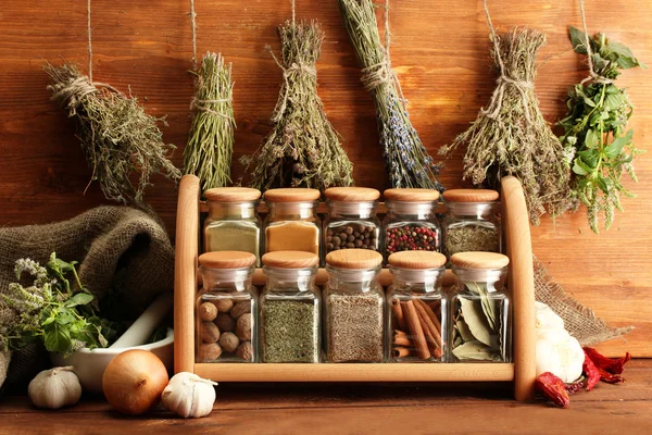 Szárított gyógynövények, fűszerek és borsozzuk, fából készült háttér — Stock Fotó