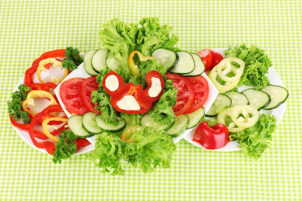 Gehakte groenten en saus op plaat op groene tafellaken — Stockfoto