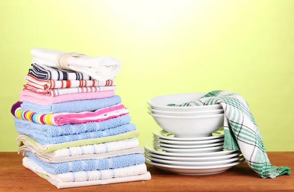 Kitchen towels with dishes on green background close-up — Stock Photo, Image