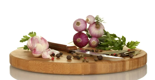Alho jovem e cebola na tábua de corte com vegetação, pimenta e faca isolada em branco — Fotografia de Stock