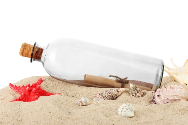 Glazen flesje met opmerking binnen op zand geïsoleerd op wit — Stockfoto