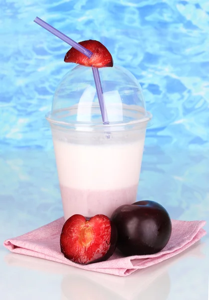 青い海の背景上のテーブルにフルーツとおいしい牛乳を振る — ストック写真