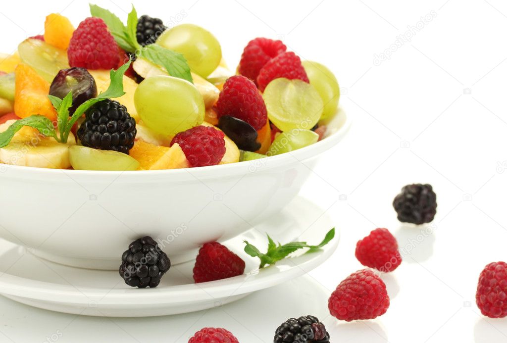 Fresh fruits salad in bowl and berries, isolated on white