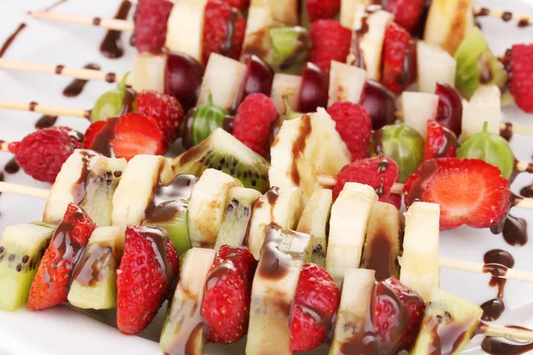 Frutas y bayas mezcladas en brochetas con chocolate de cerca — Foto de Stock