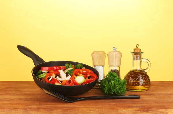 黄色の背景に野菜とフライパン — ストック写真