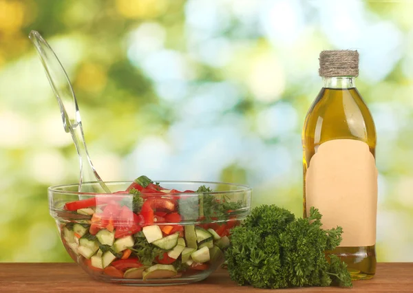 Fresh salad and oil on green background — Stock Photo, Image