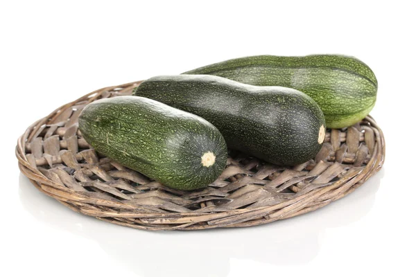 Frische Zucchini auf Weidenmatte isoliert auf weiß — Stockfoto