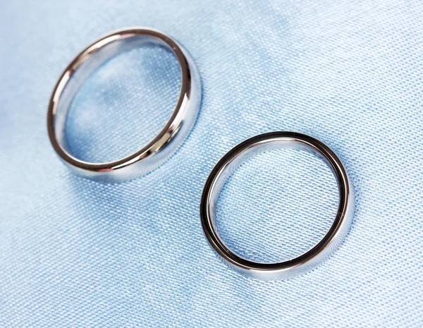 Обручальные кольца на атласной подушке крупным планом — стоковое фото
