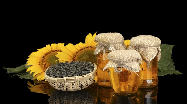 Sunflower oil and sunflower isolated on black — Stock Photo, Image