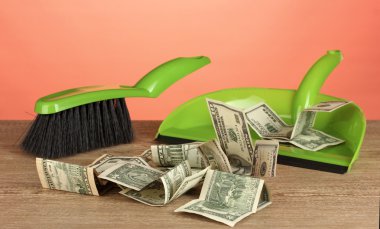 Sweeps money in the shovel on colorful background close-up clipart