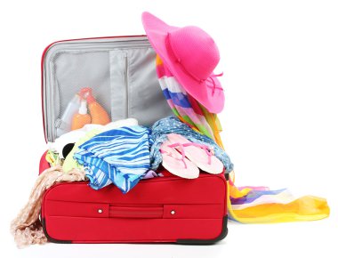 Suitcase with summer clothes, a hat and suntan isolated on white