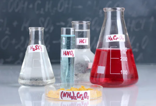 様々 な酸および黒板の背景に他の化学薬品と試験管 — ストック写真