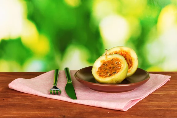 Green passion fruit in the plate on bright green background — Stock Photo, Image