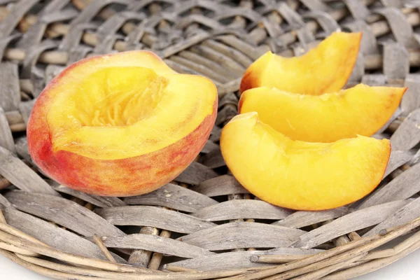 Stock image Ripe peaches on wicker mat close-up