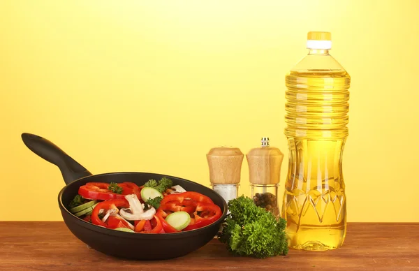 Сковородка с овощами на желтом фоне — стоковое фото