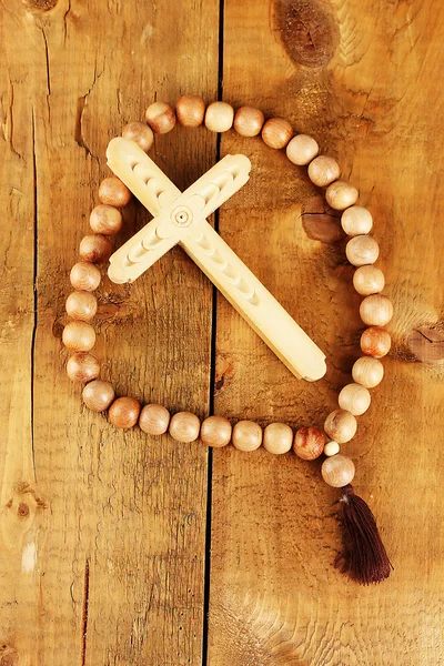 Las cuentas De madera del rosario sobre el fondo de madera el primer plano — Foto de Stock