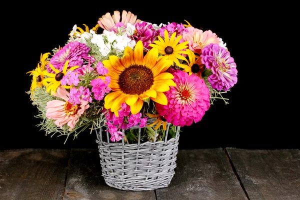 Piękny bukiet kwiatów jasny na drewnianym stole na czarnym tle — Zdjęcie stockowe