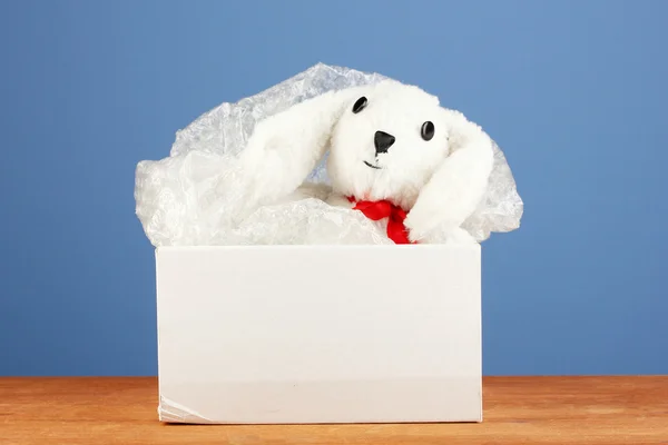 Opened parcel with a child's toy on blue background close-up — Stock Photo, Image