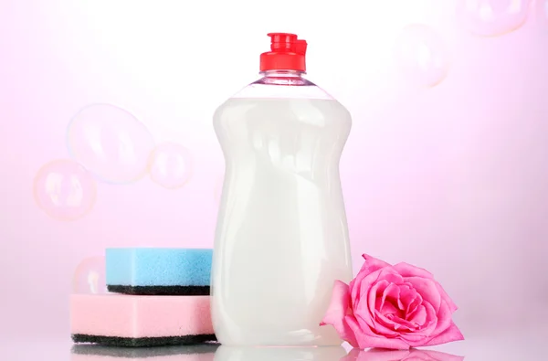 洗洁精与海绵和粉红色的背景上的花 — 图库照片