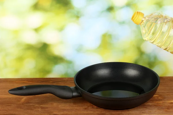 Verter aceite sobre una sartén sobre una mesa de madera —  Fotos de Stock