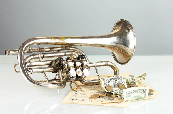 Musikinstrument med pengar på grå bakgrund — Stockfoto