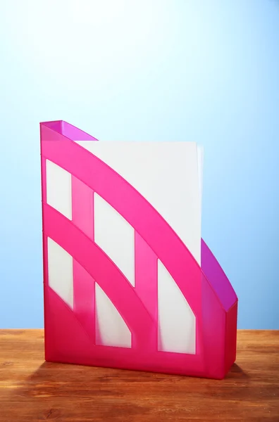 Розовый поднос для бумаг на синем фоне крупным планом — стоковое фото