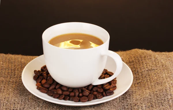 Secangkir kopi pada pemecatan pada latar belakang coklat — Stok Foto