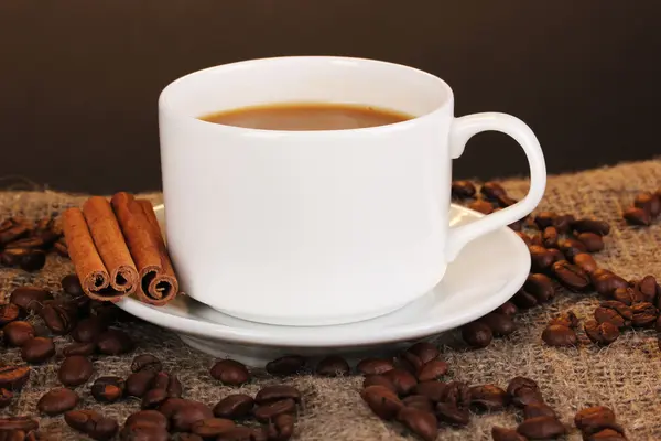Kopp kaffe på säckväv på brun bakgrund — Stockfoto