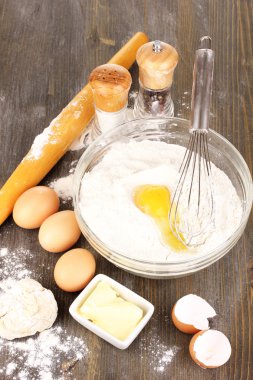 Eggs, flour and butter close-up on wooden table clipart