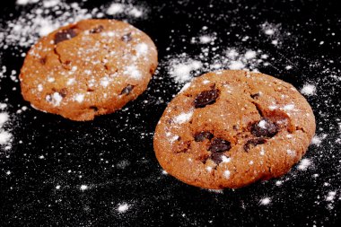 Chocolate chips cookies isolated on black clipart