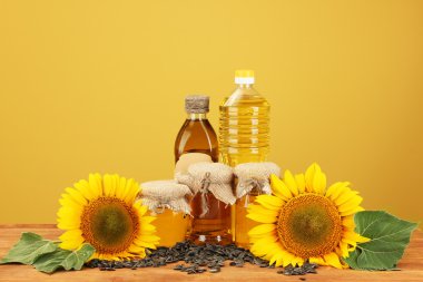 Sunflower oil and sunflower on yellow background clipart