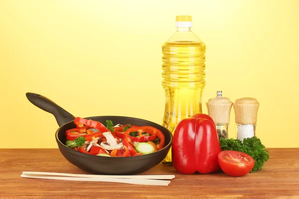 Sartén con verduras sobre fondo amarillo — Foto de Stock