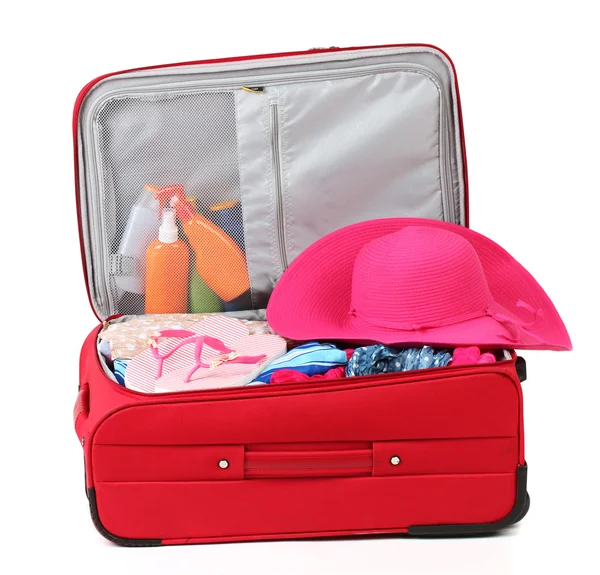 Suitcase with summer clothes, a hat and suntan isolated on white — Stock Photo, Image