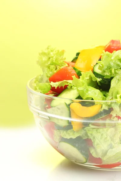 Verse groenten Salade in transparante kom op groene achtergrond — Stockfoto