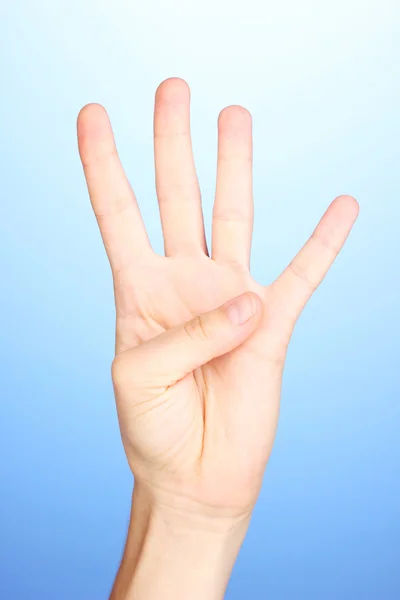 Ręka, co znak na niebieskim tle — Zdjęcie stockowe