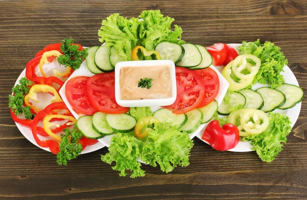みじん切り野菜と木製テーブル上プレート上のソース — ストック写真