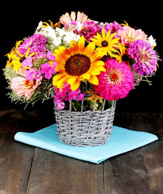 Beautiful bouquet of bright flowers on wooden table on black background clipart