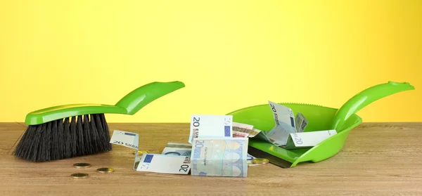 Veegt geld in de schop op kleurrijke achtergrond close-up — Stockfoto