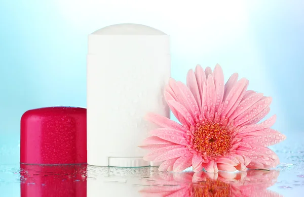 Dezodorant z kwiatów na niebieskim tle — Zdjęcie stockowe