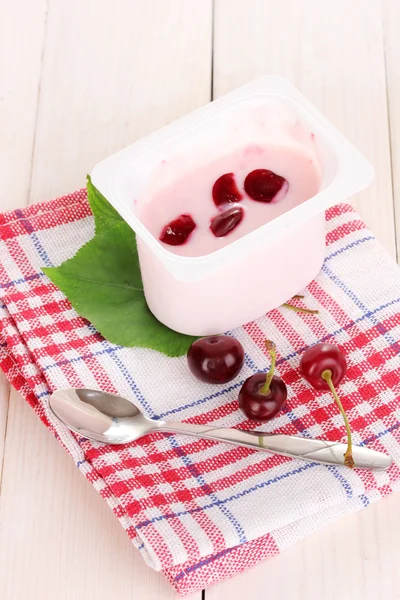 Yoghurt med körsbär på trä bakgrund — Stockfoto