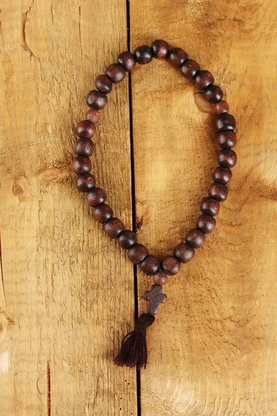 The Wooden rosary beads on wooden background close-up — Stock Photo, Image