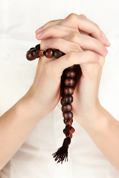 Руки в молитве с распятием крупным планом — стоковое фото