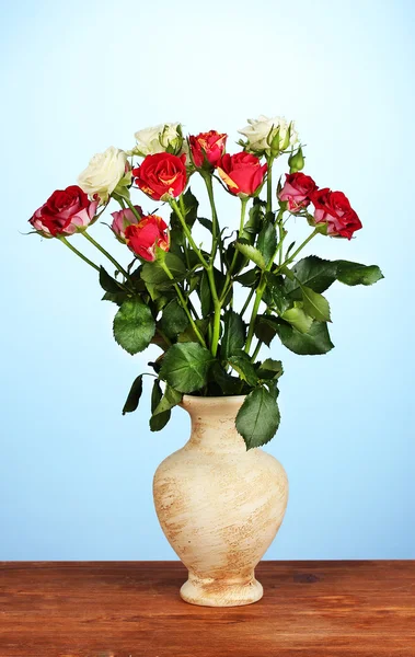 青色の背景はクローズ アップの花瓶に美しいバラの花 — ストック写真
