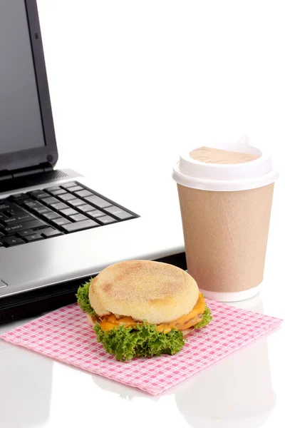 Äta på arbetsplats nära laptop — Stockfoto