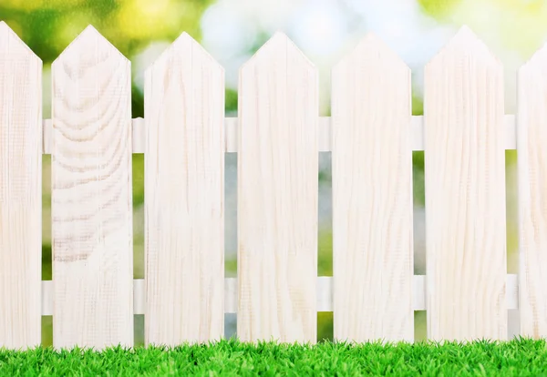 Houten hek en groen gras op lichte achtergrond — Stockfoto