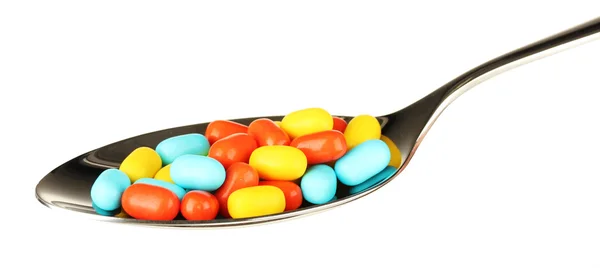 Pílulas coloridas na colher no fundo branco close-up — Fotografia de Stock