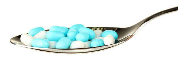 Красочные таблетки на ложке на белом фоне крупным планом — стоковое фото