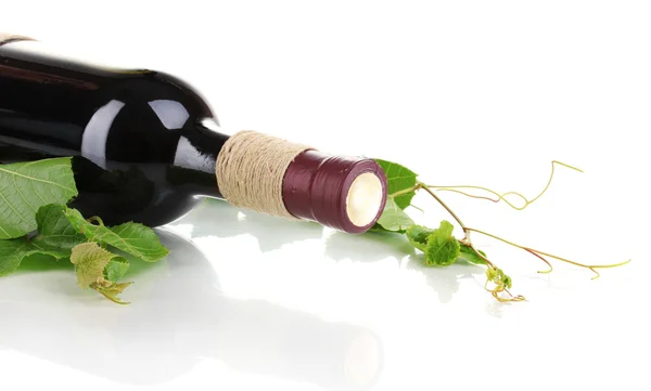 stock image Bottle of wine with grape leaves isolated on white