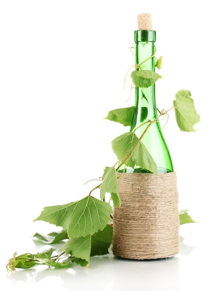 stock image Bottle of wine with grape leaves isolated on white